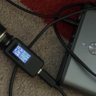 A USB-C power meter connected to an Anker battery showing 12.9 V 2.6 A / 33W