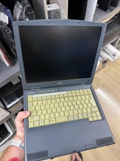 A gray Fujitsu FMV-610NU2 laptop, but where normally a trackpad would be, there is just a gray expanse of plastic.