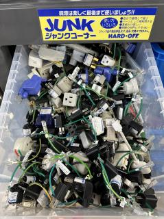 A plastic bin full of three-pin grounded plug to 2-pin+ground wire adapters