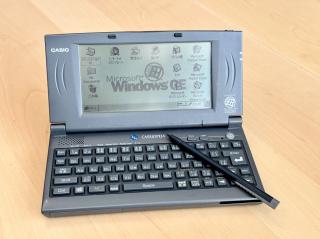 A small pocket computer with a greyscale screen and a stylus. It says Casio Cassiopeia and the wallpaper says Windows CE.