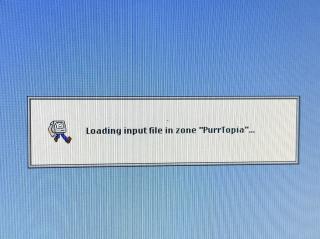 A dialog in System 7 style that says “Loading input file in zone PurrTopia.”