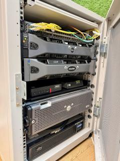 A server rack, with the focus on a Lenovo ThinkCentre Tiny and an NTT 10G-ONU