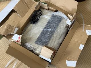 An ImageWriter II in bubble wrap in a half open box on the floor