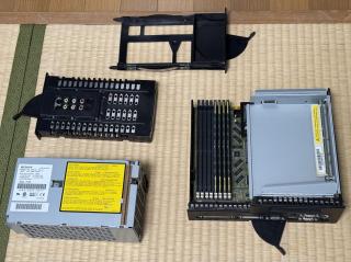 Four internal components laid out on the floor - logic board, drive tray, video card, PSU
