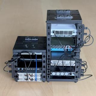 Rear of the server rack showing fans and with black power cables connecting the severs to PDUs