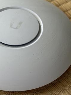 A Closeup of a white disc with greasy streaks on it and a logo that is coming off