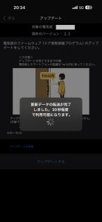A screenshot of an iPhone app.There is text in Japanese, a graphic of a person standing in front of a door, and a modal dialog with a spinner in it.Foreground window更新データの転送が完了しました。30秒程度で利用可能になります。Background window アップデート対象の電気錠：現在のバージョン：2.2電気錠のファームウェア （ドア側制御器プログラム）のアップデートをしてください。＜注意＞アップデートが完了するまでの間、電気錠とスマートフォンの距離を 1m以内に保ってください。5分〜10分アップデートの内容アップデートする