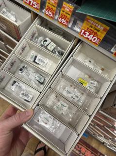 Hand holding a box of small electronic components in a store aisle.