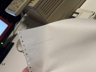 A photo of a tractor feed dot matrix printout that says “Hello from System 6.0.7 Teach Text!!!”