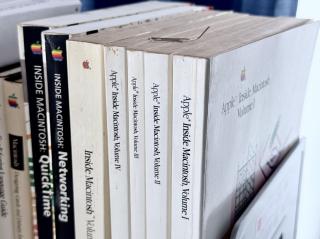 A closeup of a book stand with Apple Inside Macintosh Volumes I-V