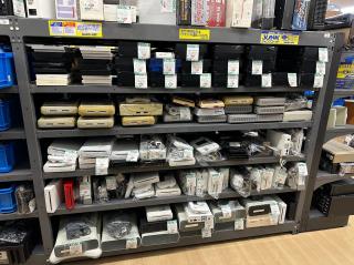 Shelves full of old game consoles: Famicom, Super Famicom, Sega, Nintendo Wii, Wii U, Xbox 360, Playstation 2. Oddly no N64