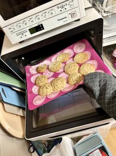 Chocolate chip cookies being taken out of an oven