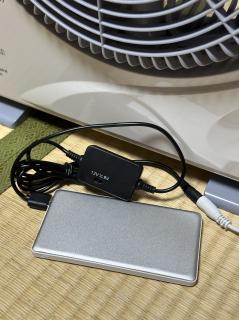 A flat USB power bank connected via USB-A to a box with a 9V<>12V switch that leads to a DC plug 
