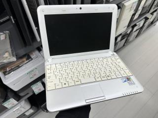 A small white laptop opened up revealing a small screen, a Japanese keyboard, and stickers saying Intel Atom inside and Designed for Windows XP