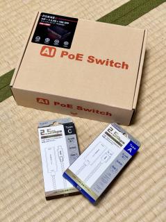 A switch box that says AI PoE Switch and two boxes for 2.5 GbE USB dongles