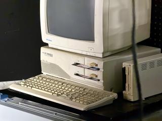 An NEC PC-9801RA with internal 5-inch floppy drives and an external 3.5in floppy drive. There are floppies in 3 of the drives. The screen is off.