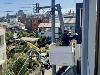 A guy on a crane lift taping together a roll of fiber. The guy from the first photo is seen in the background