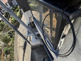 A roll of fiber coming off a pole and strapped to a balcony