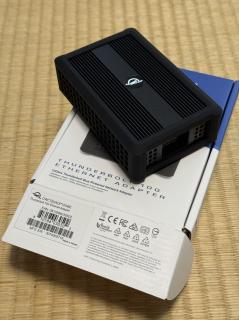 A black aluminium box with rubber padding and an OWC logo atop a box that says Thunderbolt 10G Ethernet Adapter