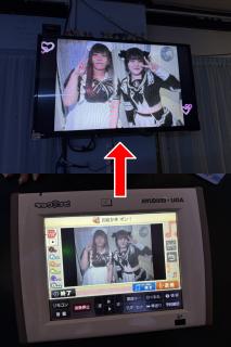 Two photos. The first one is of a karaoke remote control showing a photo with editing controls around it for drawing, adding stickers etc.There is an arrow to the second photo.The second photo shows a TV with the same photo on it.