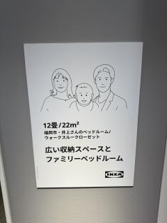 Line art family in the same style on a sign at IKEA showing a compact living bedroom for 3