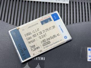 The underside of the card with a firmware version sticker on itCISCO IOS PCISCO SYSTEMSSN: JAB034040F9S16RQHL-12.0.4TCisco 1600 R IOS IP/IPX/AT/IBMVersion: 12.0(4)TImage: c1600-bnor2sy56i-mz.Filename : x0000929© 1999 Cisco Systems, Inc.CELL : 12