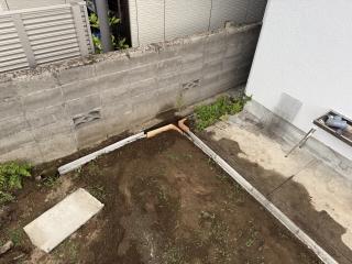 A yard kind of dug up and a concrete trough put in place, with a wooden form as well