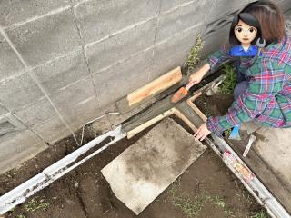 A woman shaping concrete in a wooden mold
