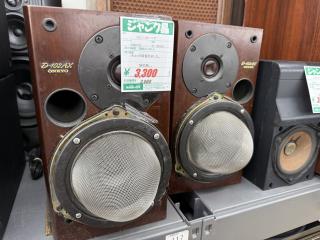 Two Onkyo D-102AV speakers with what looks like kitchen colanders glued to the front of the speaker cones