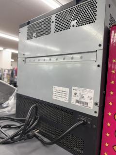 The rear of the device with nothing but a power cord and a sticker that saysネットコミュニティシステム αNXαNX typeL-「１」NXL-ME-＜1＞