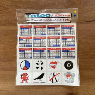 A sheet of stickers with the title Tatoo[sic] 1,280yenfor Power Book520,520c,540cThe stickers include monthly calendars fro July 1994 to June 1995, and then random things like a panda, a mom heart, an 8-ball, a devil, a crow with the text “CODE NAME: BLACKBIRD”, an anarchy symbol, and a graphic of a PowerBook 1xx-series trackball!