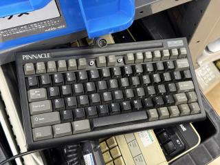 A compact keyboard with a round DIN plug, branded PINNACLE