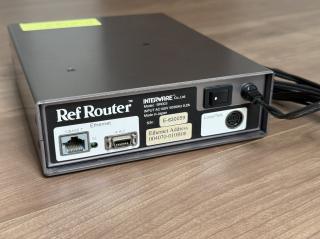 Rear of the box, revealing Ethernet 10BASE-T, AAUI, LocalTalk. There is an MAC address starting with 004070, a model number BR003 and Made in Japan. Input is AC100V only.